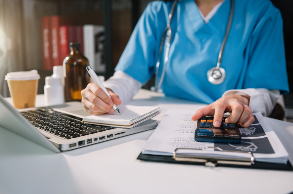 Doctor adding up expenses.